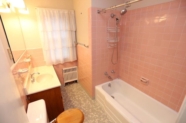 full bathroom featuring tiled shower / bath, radiator heating unit, tile patterned flooring, vanity, and toilet