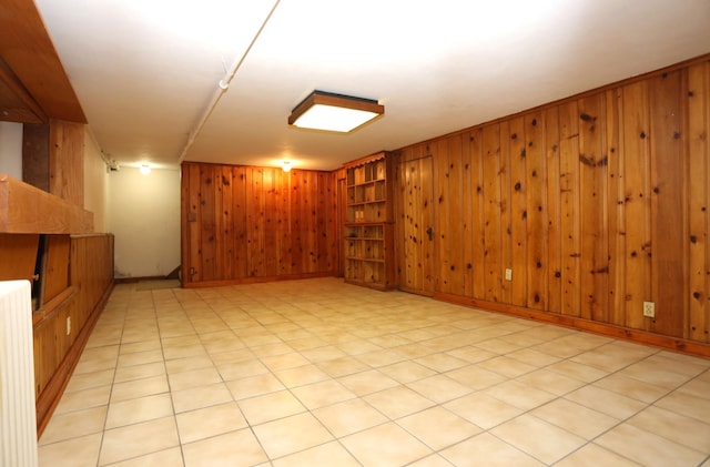 basement featuring radiator and wood walls