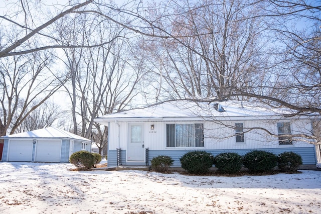 view of front of home featuring a garage and an outbuilding