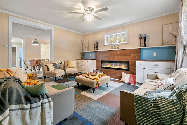 living room with ceiling fan, a textured ceiling, and crown molding