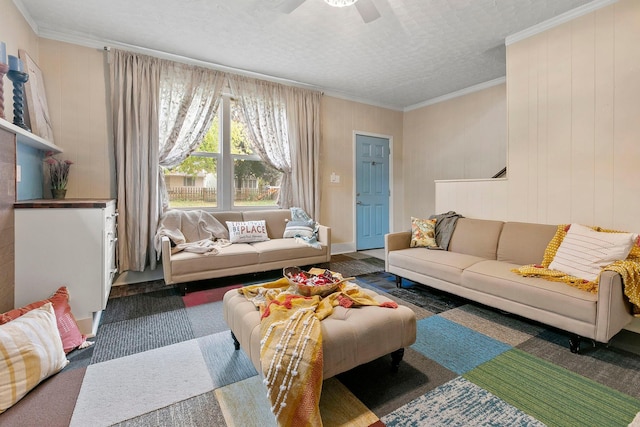 living room with ceiling fan, ornamental molding, and a textured ceiling