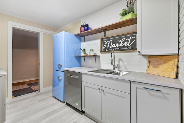 kitchen with sink, stainless steel dishwasher, light hardwood / wood-style flooring, and fridge