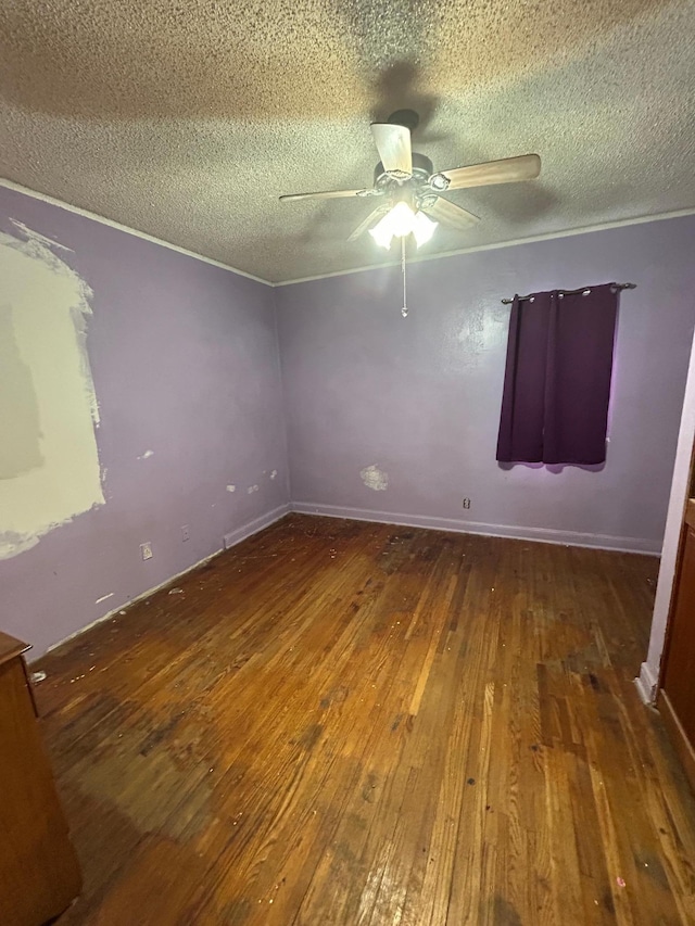 empty room featuring ceiling fan, dark hardwood / wood-style flooring, and a textured ceiling