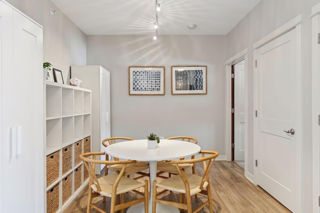 dining area featuring track lighting and light hardwood / wood-style floors