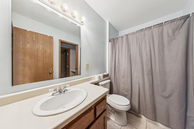 bathroom with tile patterned flooring, vanity, toilet, and walk in shower