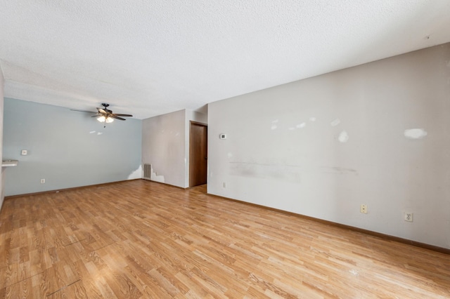 empty room with ceiling fan, a textured ceiling, and light hardwood / wood-style flooring