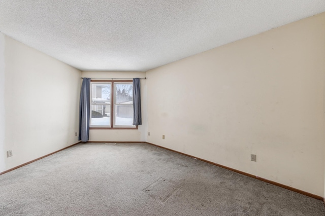 carpeted empty room featuring a textured ceiling