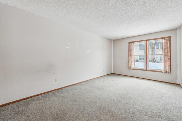 empty room with carpet floors and a textured ceiling