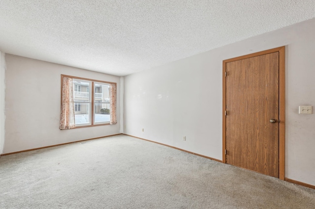 carpeted spare room featuring a textured ceiling