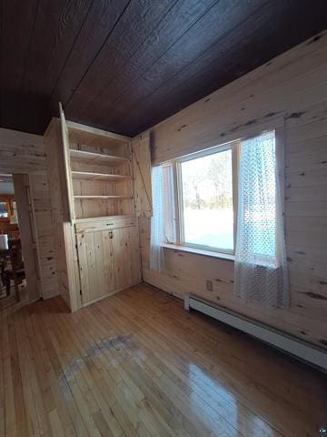 6330 Mitchell Rd, Hughes Twp, WI 54847 - bonus room featuring wood walls, a baseboard radiator, light hardwood / wood-style flooring, and wood ceiling