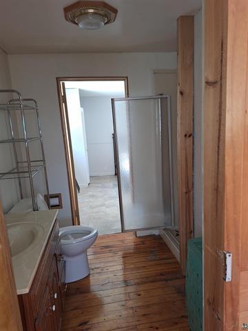 6330 Mitchell Rd, Hughes Twp, WI 54847 - bathroom with a shower with door, toilet, vanity, and hardwood / wood-style flooring