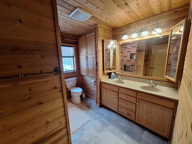 6330 Mitchell Rd, Hughes Twp, WI 54847 - bathroom with wooden ceiling, wood walls, vanity, and toilet