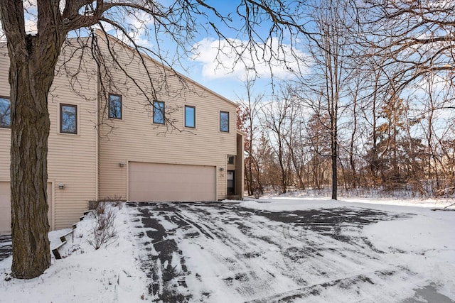 view of snow covered exterior featuring a garage