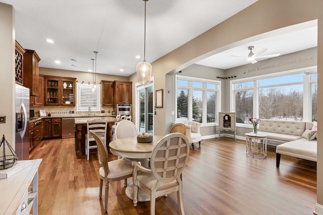 dining space with sink, ceiling fan, and light hardwood / wood-style flooring