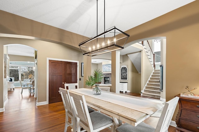 dining space featuring a fireplace and dark wood-type flooring