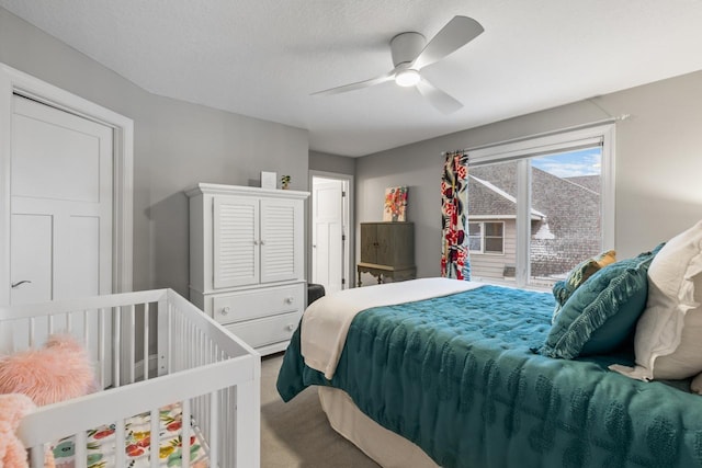 carpeted bedroom with ceiling fan and a textured ceiling