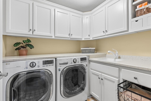 washroom with cabinets, separate washer and dryer, and sink