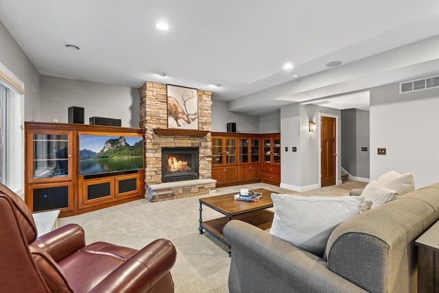 carpeted living room with a stone fireplace