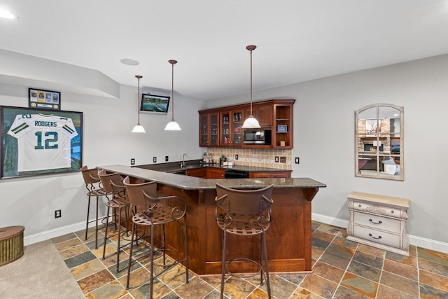 bar with sink, backsplash, and hanging light fixtures