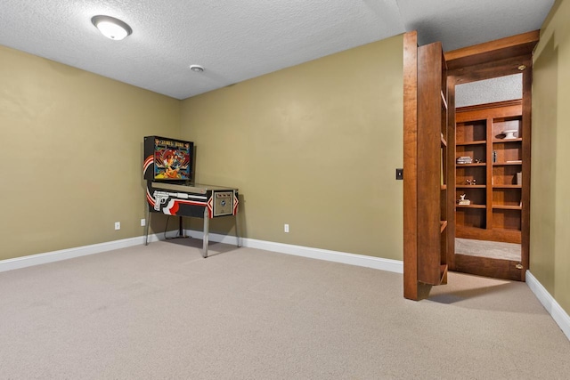 rec room featuring a textured ceiling and light carpet