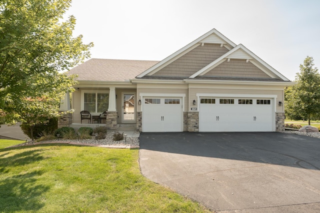 craftsman inspired home featuring a porch, a garage, and a front yard