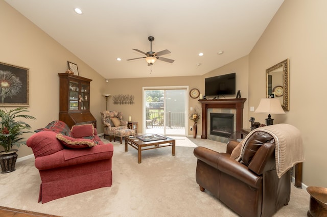 carpeted living room featuring ceiling fan, lofted ceiling, and a tile fireplace