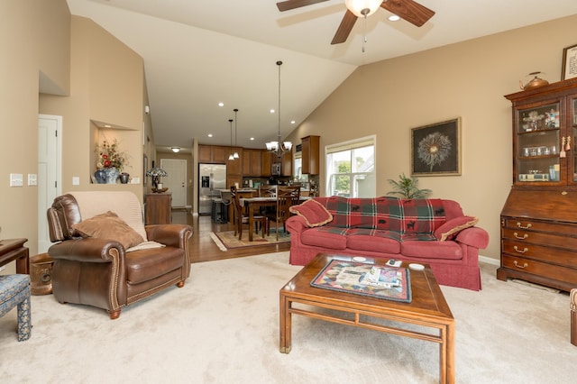 carpeted living room featuring ceiling fan with notable chandelier and lofted ceiling