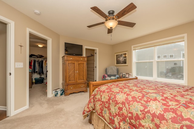 carpeted bedroom with ceiling fan, a spacious closet, and a closet