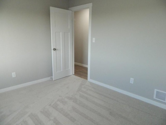 unfurnished room featuring light carpet