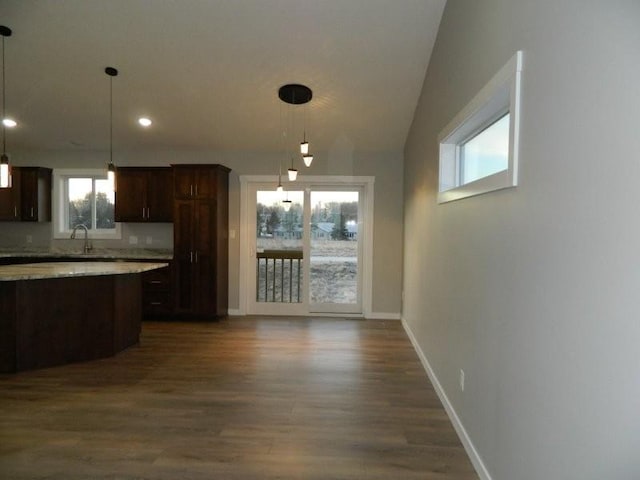 kitchen featuring sink, decorative light fixtures, vaulted ceiling, dark brown cabinets, and dark hardwood / wood-style flooring