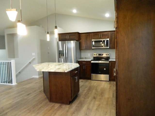 kitchen with light stone counters, decorative light fixtures, a center island, light wood-type flooring, and appliances with stainless steel finishes