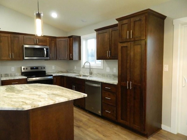 kitchen with stainless steel appliances, vaulted ceiling, sink, and light wood-type flooring