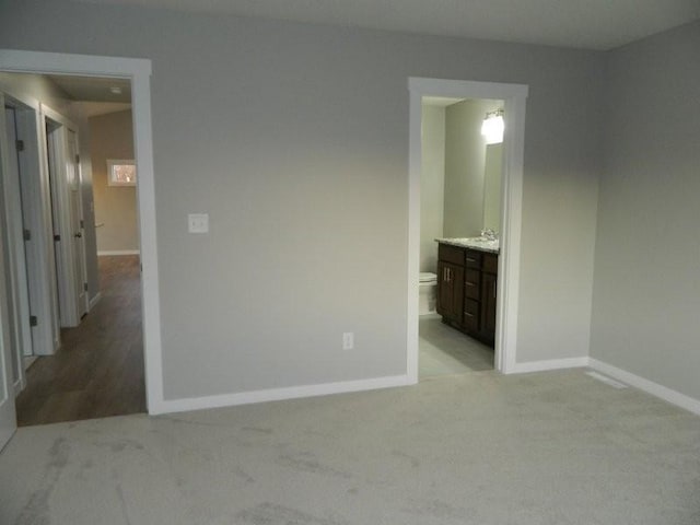 unfurnished bedroom with light carpet and ensuite bath