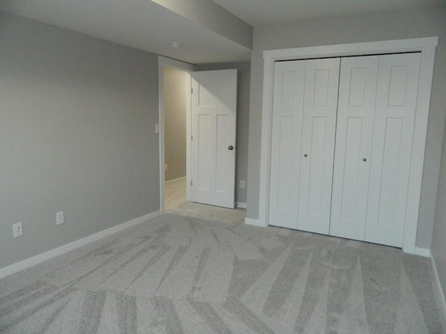 unfurnished bedroom featuring light colored carpet and a closet