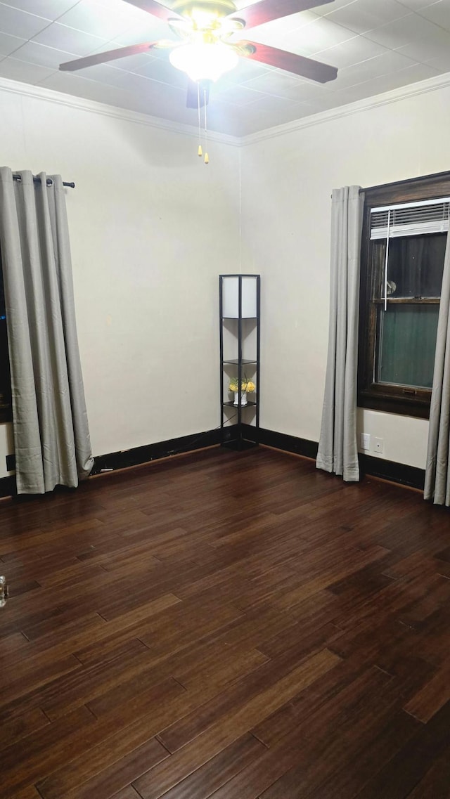 empty room featuring ornamental molding, dark hardwood / wood-style floors, and ceiling fan