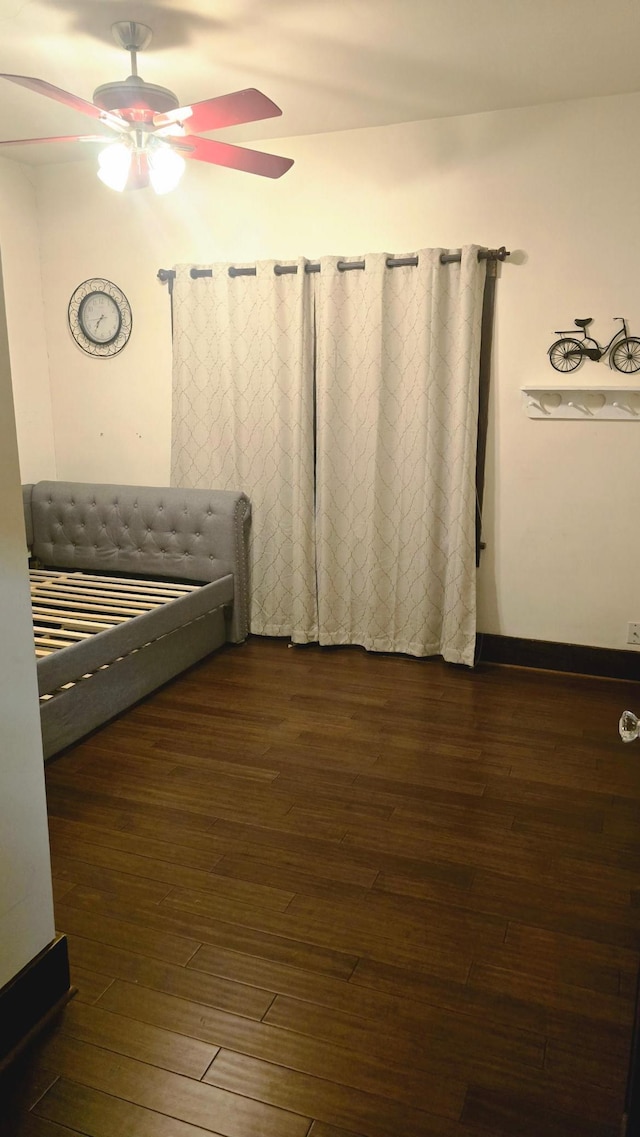 unfurnished bedroom featuring dark wood-type flooring and ceiling fan