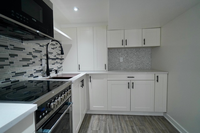 kitchen featuring white cabinets, decorative backsplash, and high end range