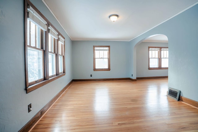 spare room featuring ornamental molding and light hardwood / wood-style floors