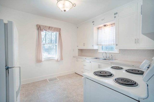 kitchen featuring sink, white cabinetry, white appliances, and tasteful backsplash