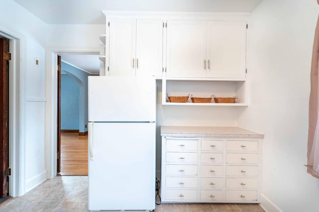 kitchen featuring white cabinets and white refrigerator