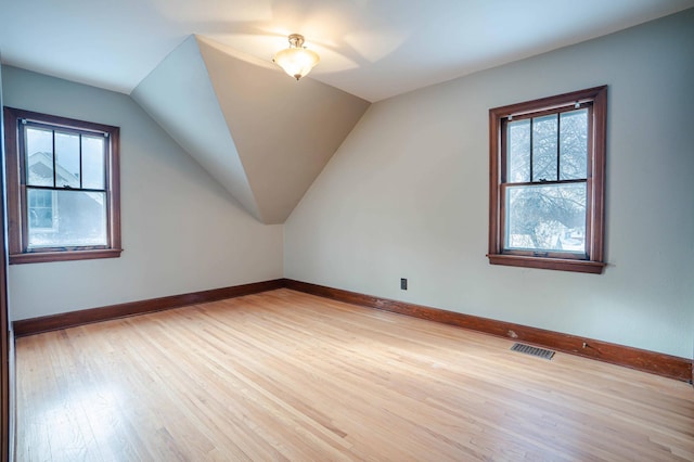 bonus room with vaulted ceiling and light hardwood / wood-style flooring