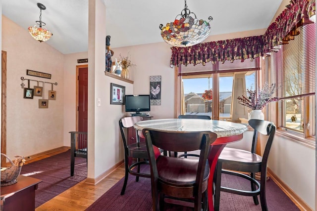 dining area featuring vaulted ceiling, a chandelier, and hardwood / wood-style floors