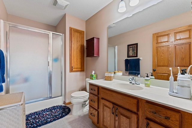 bathroom featuring toilet, walk in shower, tile patterned floors, vanity, and a textured ceiling