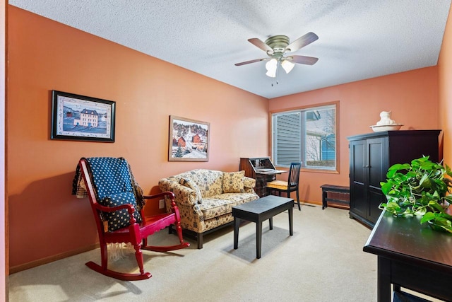 interior space featuring light colored carpet, ceiling fan, and a textured ceiling