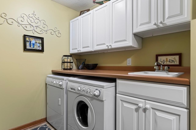 washroom with sink, washer and clothes dryer, a textured ceiling, and cabinets