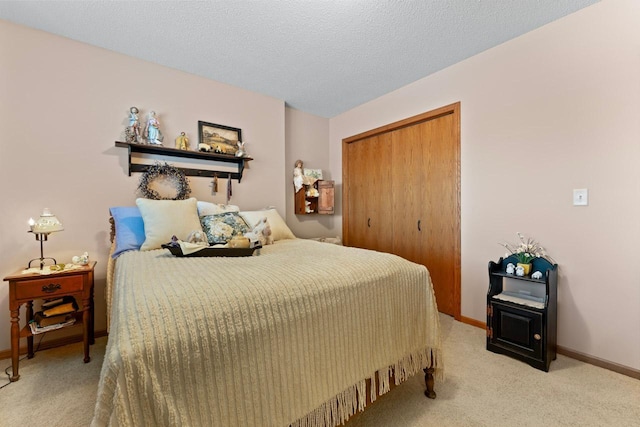 bedroom with a closet, light carpet, and a textured ceiling