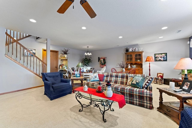 living room with a textured ceiling, light carpet, and ceiling fan with notable chandelier