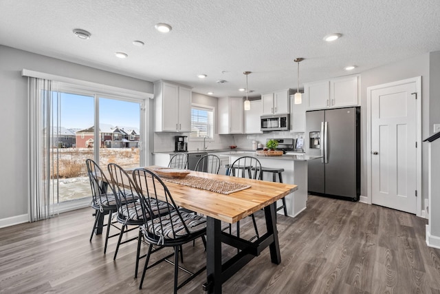 dining space with dark hardwood / wood-style floors, sink, and a textured ceiling