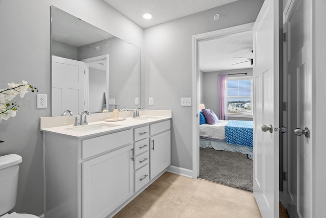 bathroom with vanity, a textured ceiling, and toilet