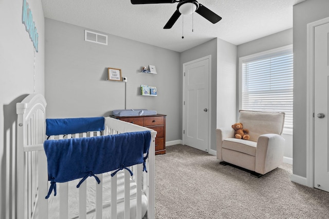 carpeted bedroom featuring a textured ceiling and ceiling fan